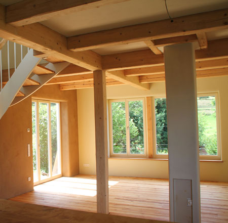 Wohnküche mit Holzbalken Lehmputz Holzofen Wandheizung in Göttingen