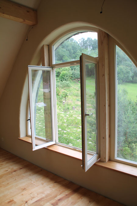 Sägespuren an Holzbalken mit Lehmputzoberfläche