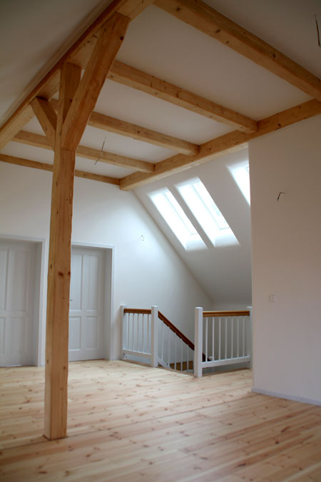 Dachgeschoss Holzhaus mit Lehmputz und sichtbaren Holzbalken in Göttingen