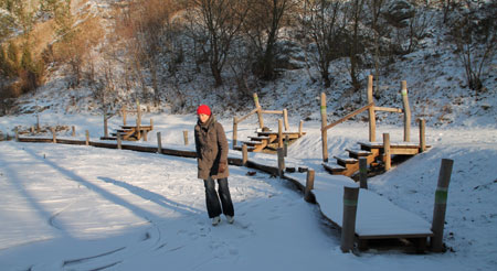 Der Badesteg im Winter mit Schlittschuhläuferin.